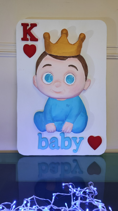 تصویر کارت بازیK با تصویری نوزاد پسر با تاج و ریسه نور