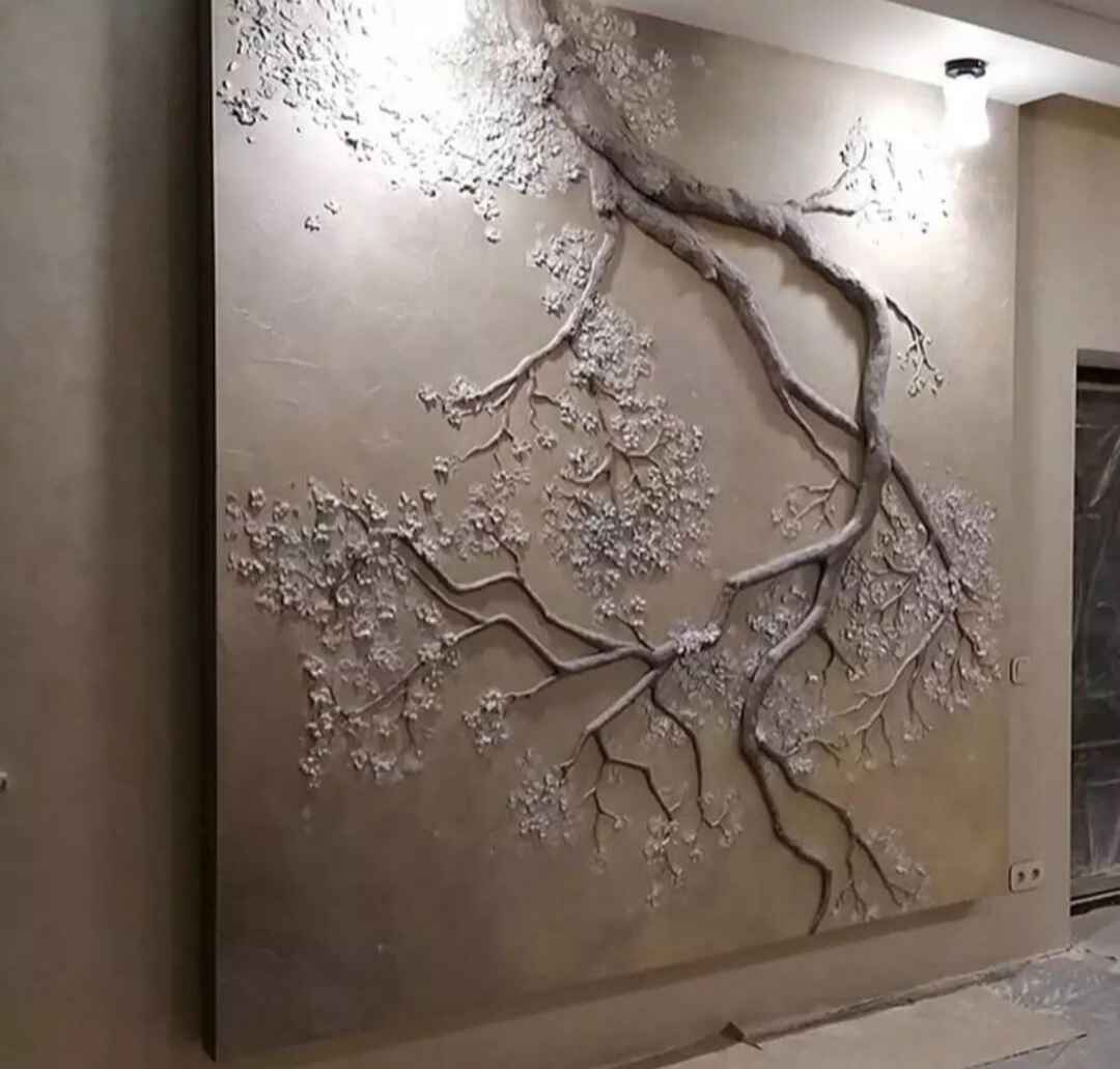 نقش‌برجسته دیواری از شاخه درخت با شکوفه‌های برجسته، ساخته‌شده از رزین/گچ با بافت طبیعی و نورپردازی بالایی که عمق را نمایان می‌کند